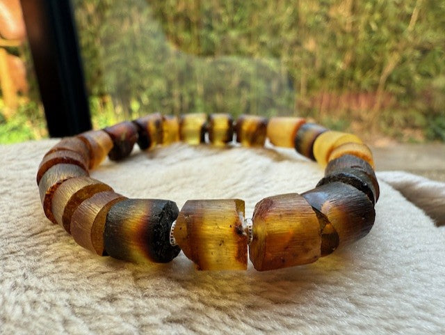 Tortoiseshell beaded bracelet on a textured surface with a blurred natural background