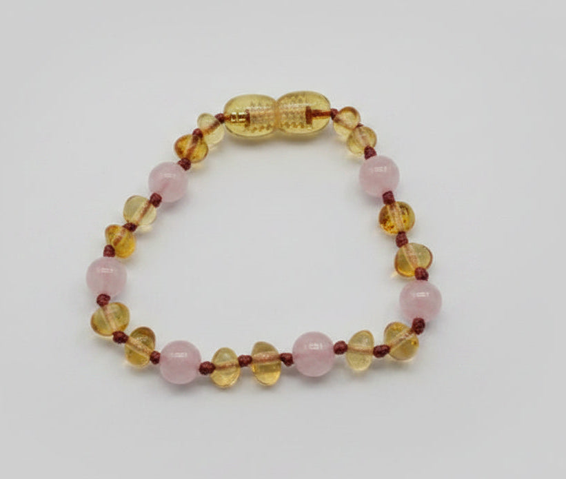 Beaded bracelet with pink, yellow, and red beads on a light background