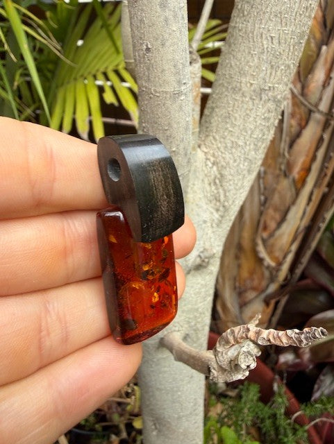 Amber Amulet of Strength & Serenity – on wood detail – Amber House