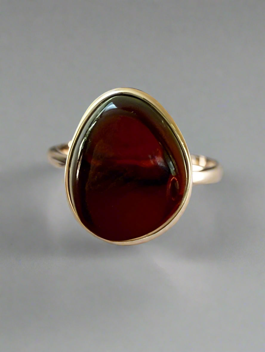 Red stone ring with silver setting on a wooden surface