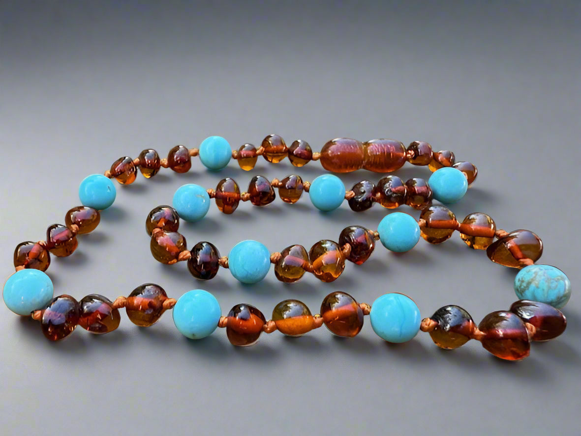 Necklace with amber and turquoise beads on a wooden surface