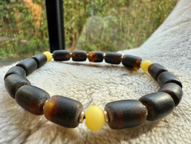 Bracelet with brown and yellow beads on a textured surface