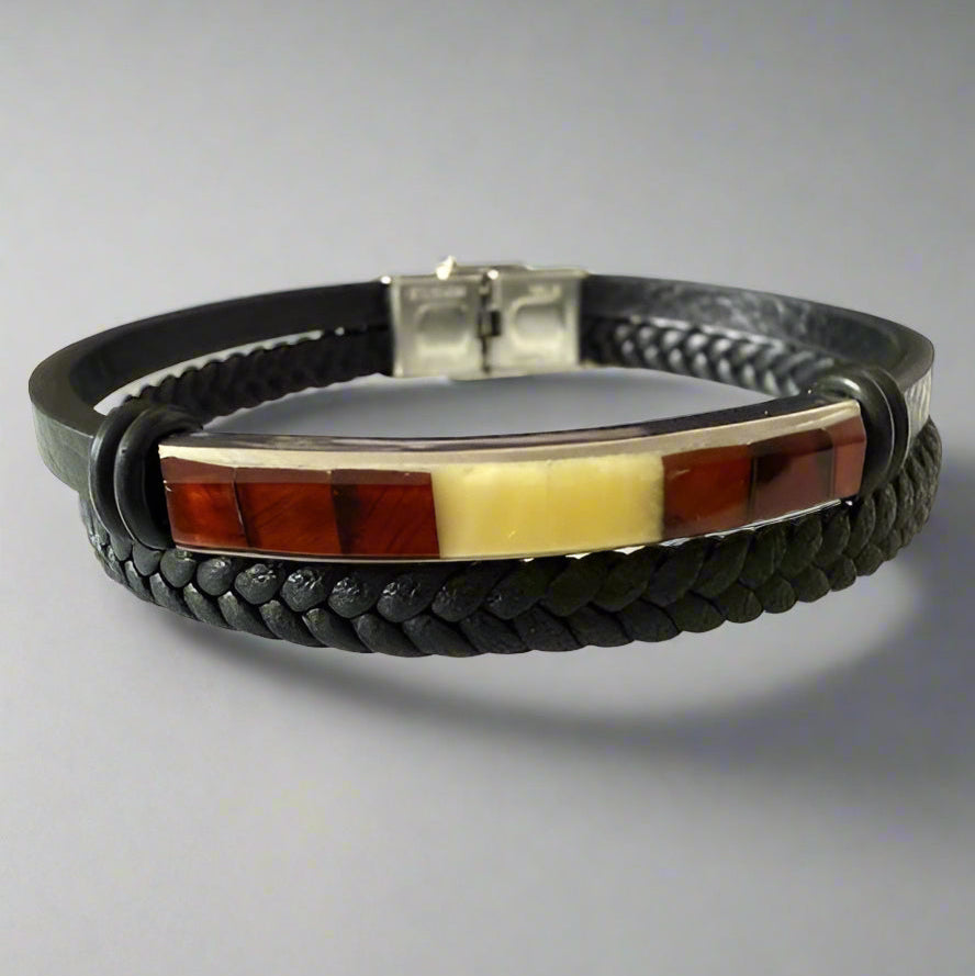 A leather men's bracelet with a cognac amber stone and a stainless steel clasp, displayed against a grey background.