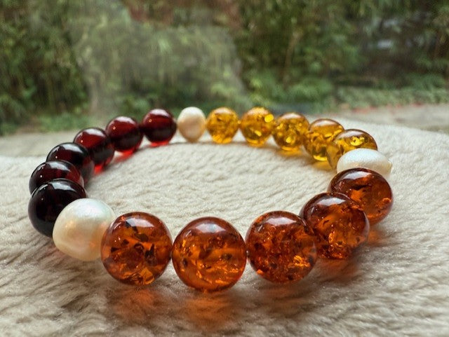 Multicolored beaded bracelet on a textured surface with a blurred natural background
