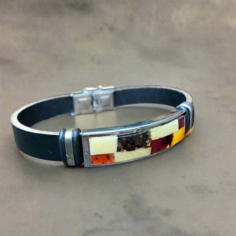 A leather bracelet with cognac amber inlays and a stainless steel clasp, displayed against a grey background.
