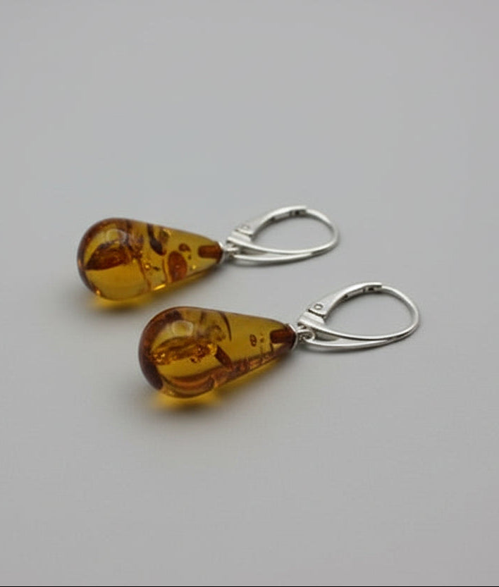 Pair of amber teardrop earrings on a light surface