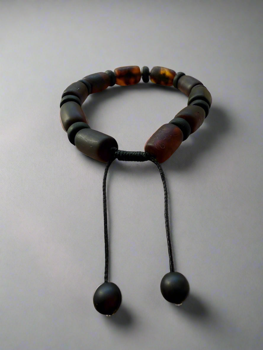 Bracelet with brown and black beads on a textured surface