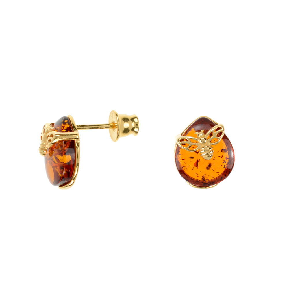 A pair of gold-plated amber earrings with a bee motif, featuring a round shape and a small hook at the top.