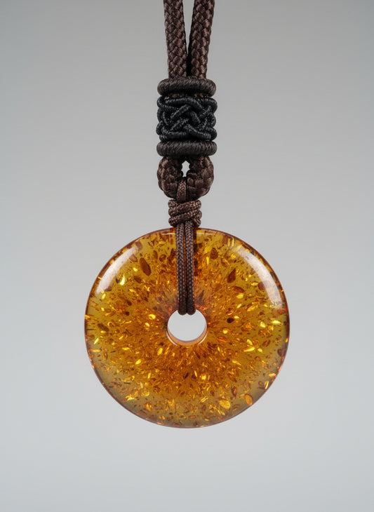 Amber-colored pendant on a brown cord against a white background
