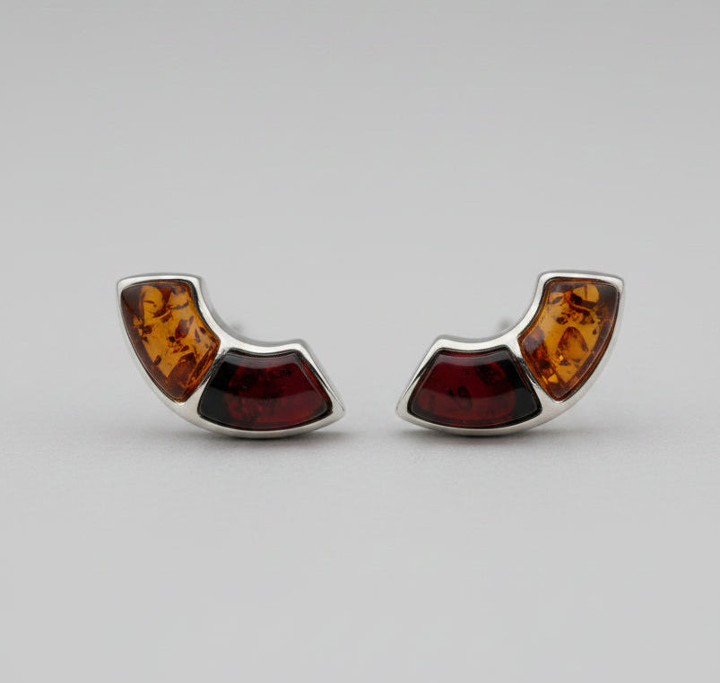 Pair of earrings with amber and silver design on a white surface