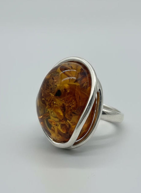 Silver ring with amber stone on a light background