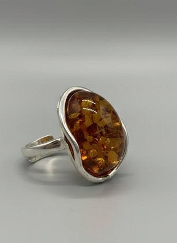 Silver ring with a large amber stone on a light background