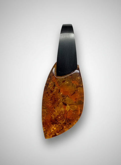 Amber stone with a black base on a textured beige surface