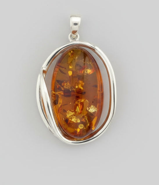 Silver pendant with amber stone on a wooden surface