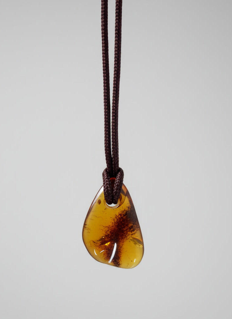 Amber guitar pick on a white background