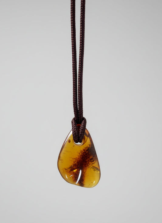 Amber guitar pick on a white background