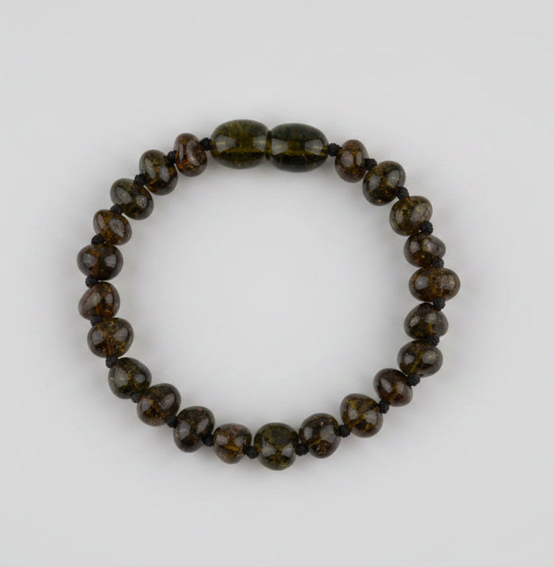 Beaded bracelet with brown and black stones on a textured beige background