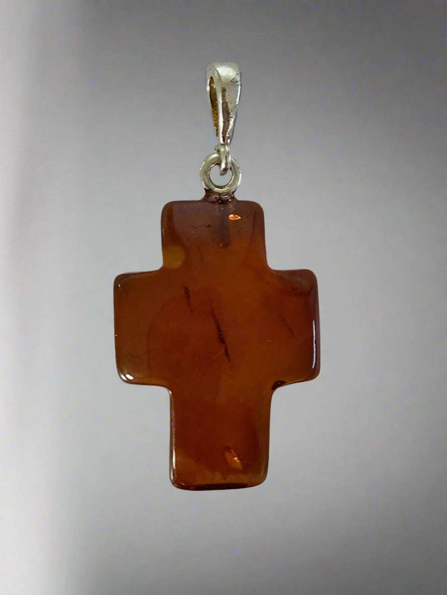 Brown cross pendant with silver chain on a light gray background