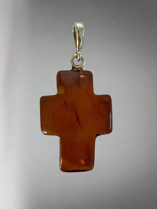 Brown cross pendant with silver chain on a light gray background