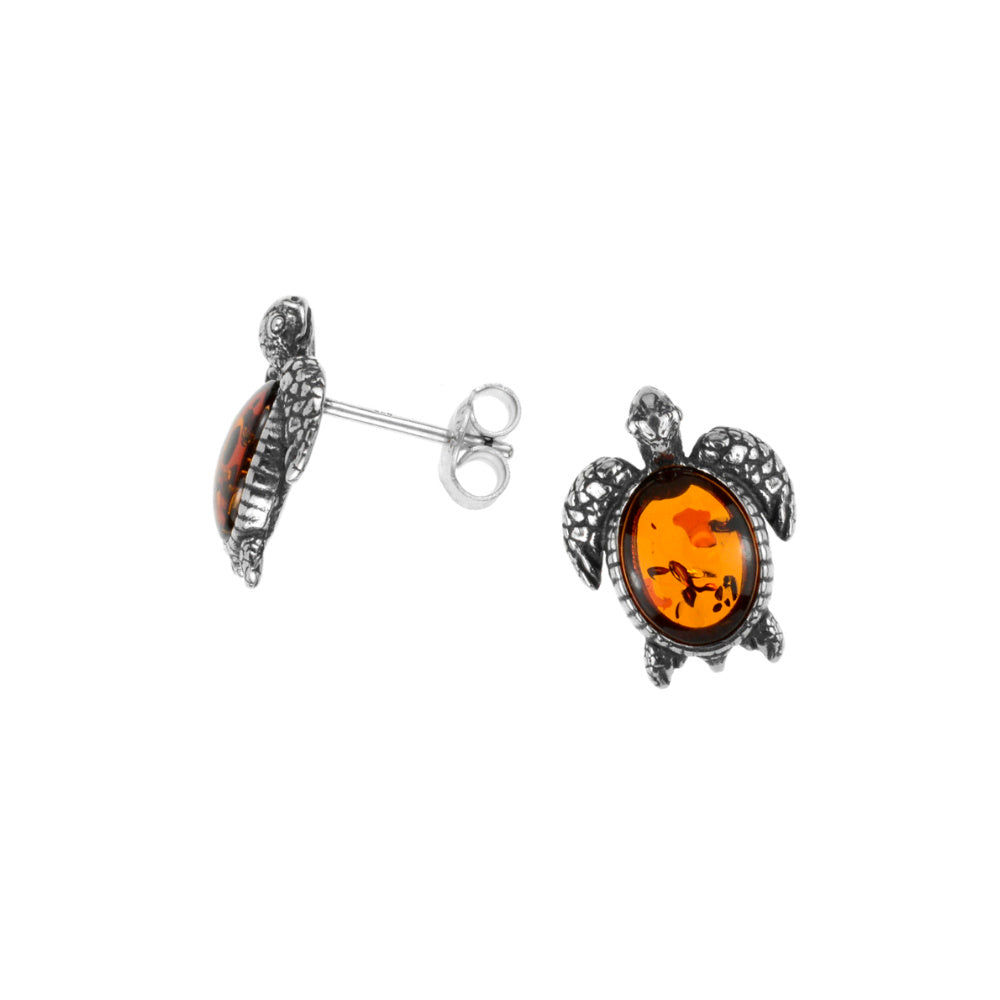 A pair of silver amber turtle earrings with intricate details on a white background.