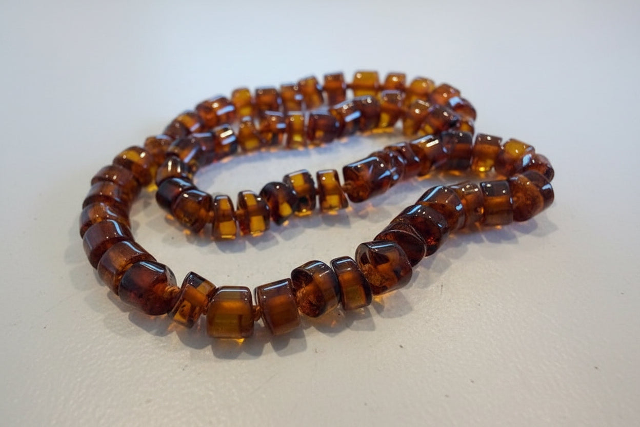 Close-up of a brown beaded necklace on a light background