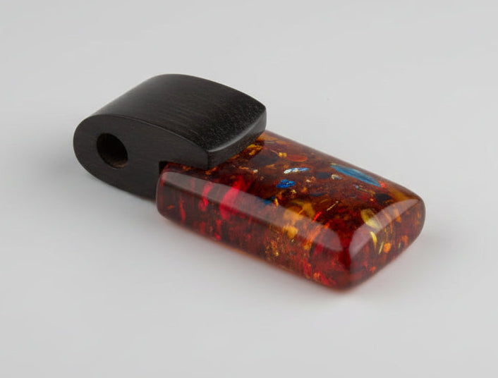 Amber-colored rectangular object with black band on wooden surface