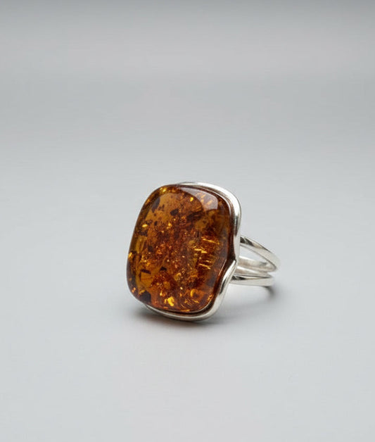 Ring with amber stone on a wooden surface