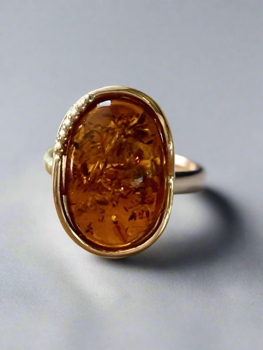 Ring with amber stone on a wooden surface