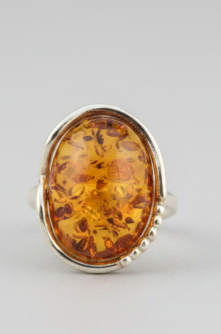 Ring with amber stone on a wooden surface