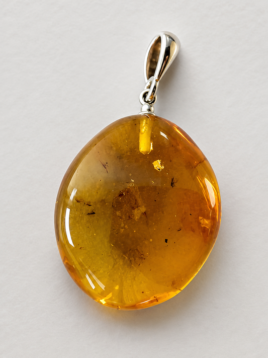Amber pendant with silver bail on a light gray background