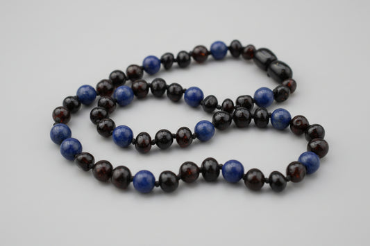 Necklace with blue and black beads on a wooden surface