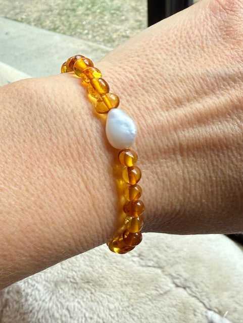 Beaded bracelet with a white stone on a wrist, blurred background