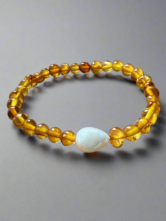 Beaded bracelet with a central white stone on a gray background