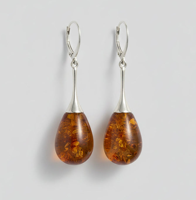 Amber teardrop earrings on a wooden surface