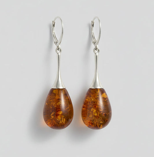 Amber teardrop earrings on a wooden surface