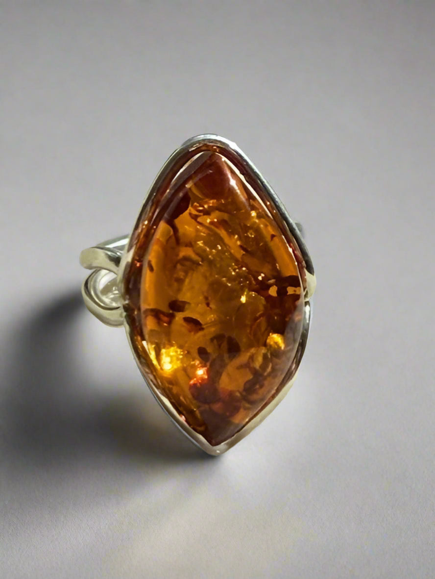 Ring with a large amber stone on a gray background