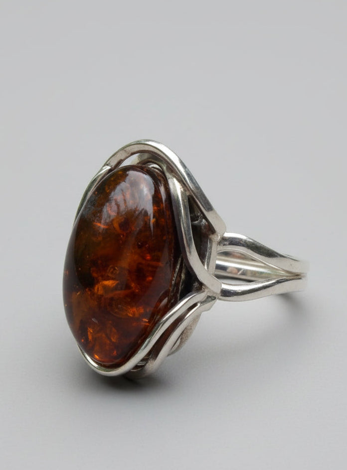 Silver pendant with amber stone on a wooden surface