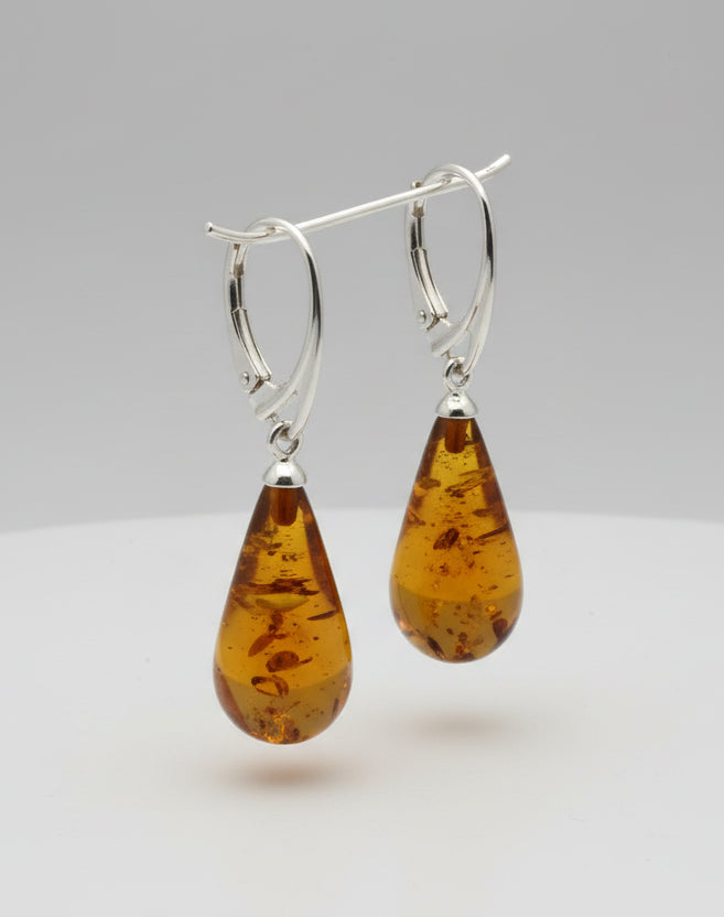 Pair of amber teardrop earrings on a white background