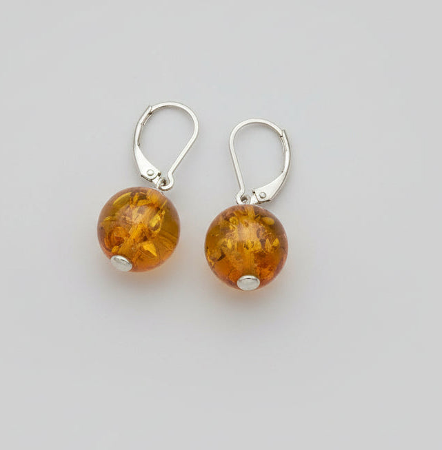 Amber-colored earrings on a wooden surface
