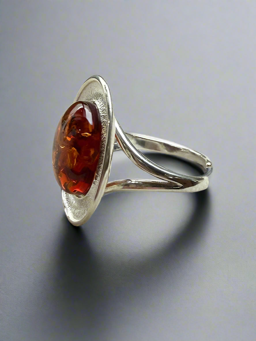 Silver ring with a amber stone on a textured surface