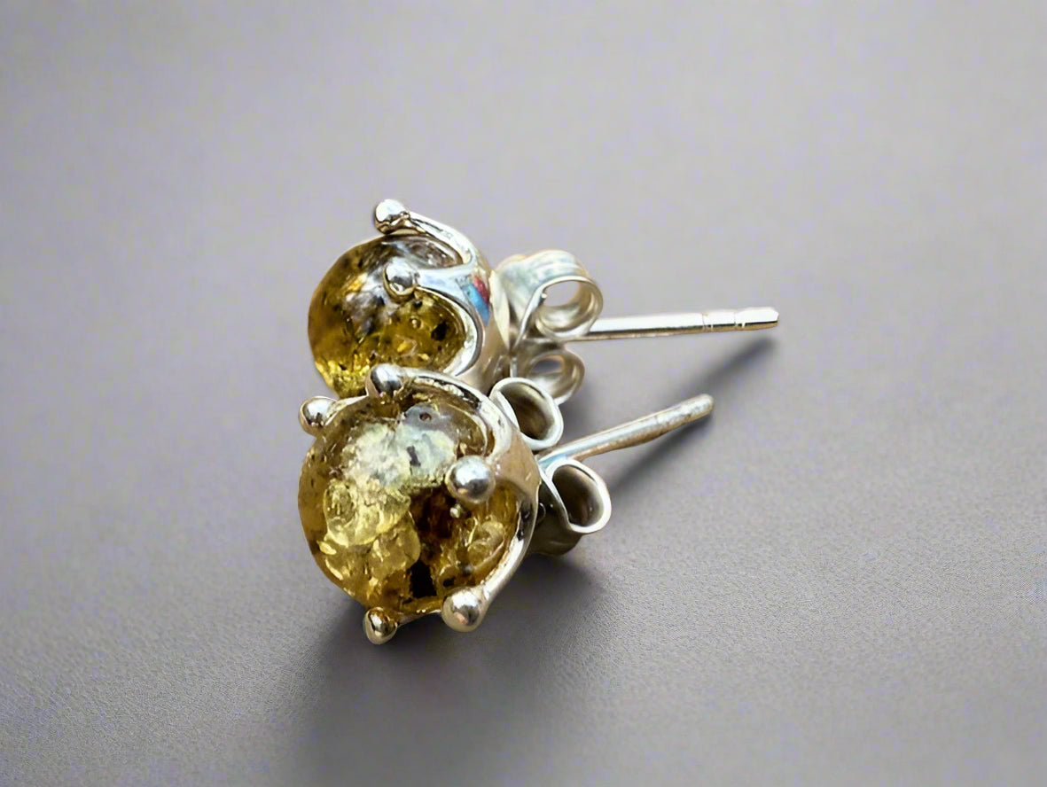 Silver earrings with amber stones on a wooden surface