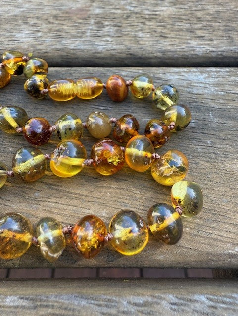 Beaded necklace with amber-colored beads on a wooden surface