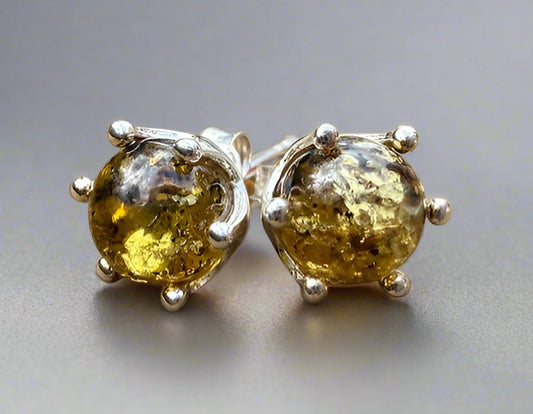Pair of amber stud earrings on a wooden surface
