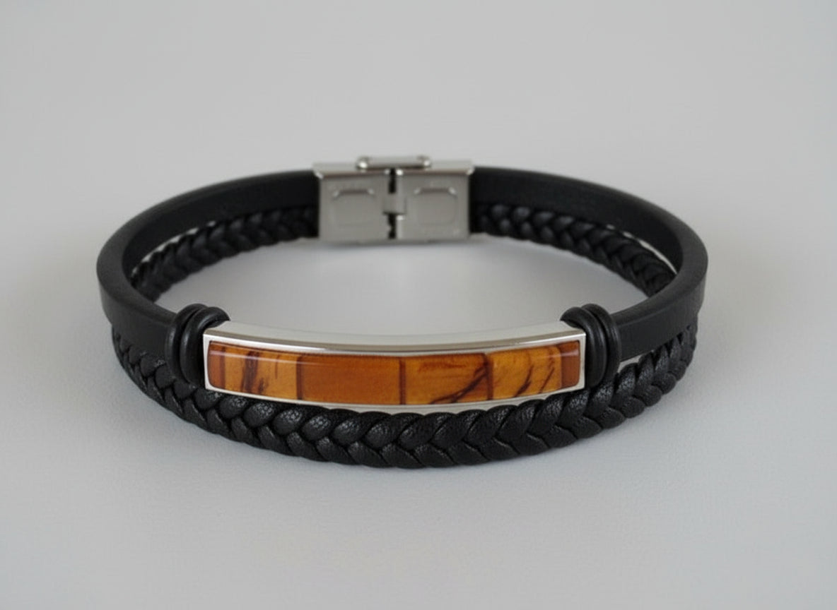 Black braided leather bracelet with a silver clasp on a light surface.