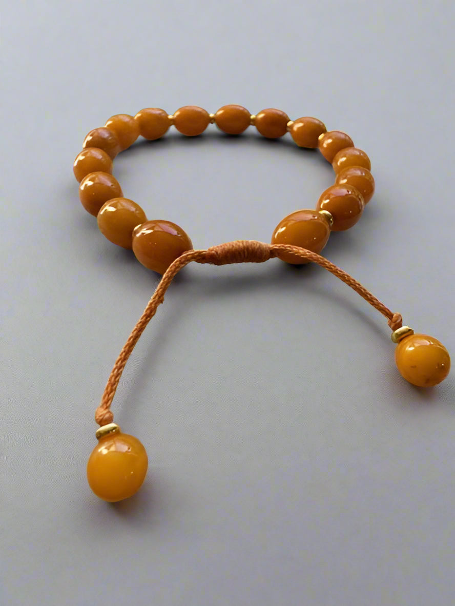 Beaded bracelet with orange beads on a textured surface