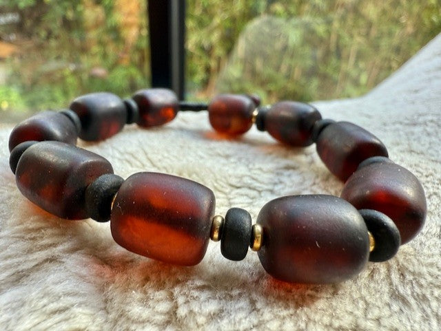 Shadow & Flame Amber Men's Bracelet on a textured surface