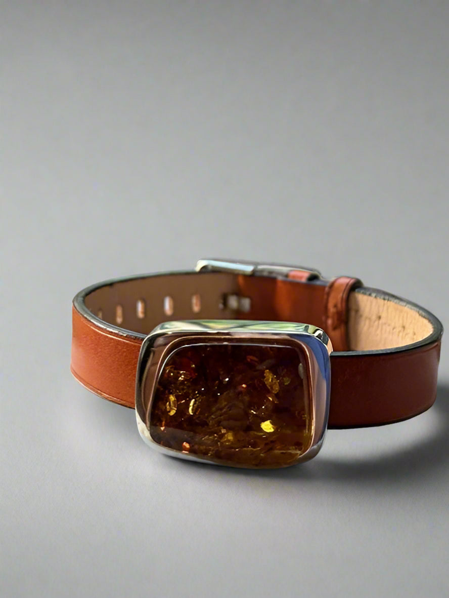 Brown leather collar with a decorative clasp on a gray background