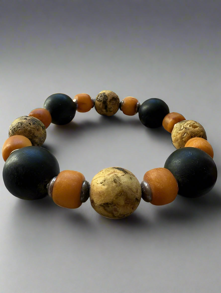 Beaded Men's Rustic Amber Bracelet, orange, and brown beads on a textured surface.