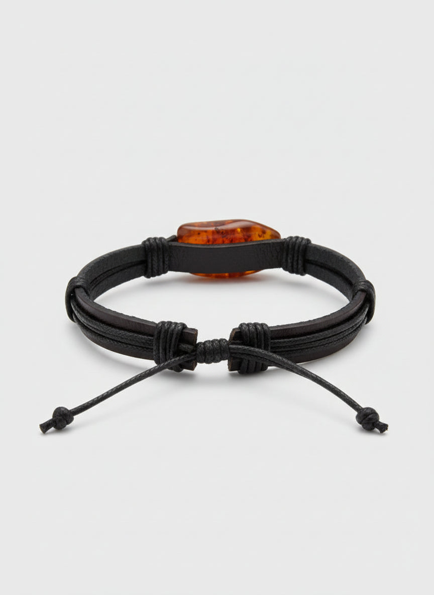 Black braided bracelet with a brown stone on a white surface