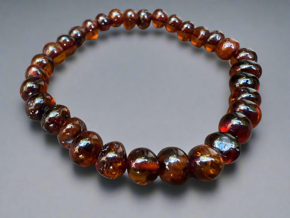 Beaded bracelet with amber-colored beads on a gray background